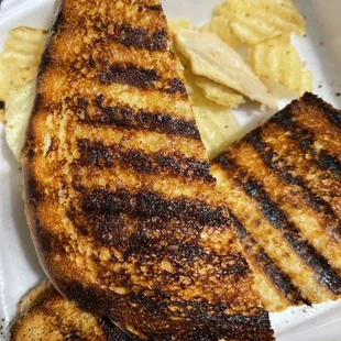 a grilled sandwich and potato chips