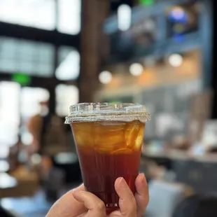 a hand holding a cup of iced coffee