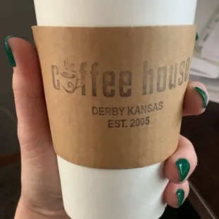 a hand holding a cup of coffee