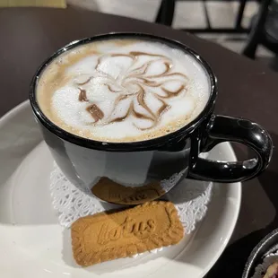 a cup of cappuccino and a biscuit