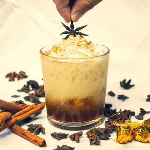 a hand sprinkling a star on top of a drink