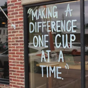 a sign in the window saying making a difference one cup at a time