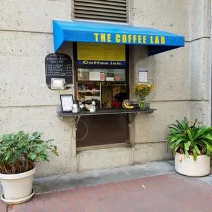 a coffee shop with a blue awning