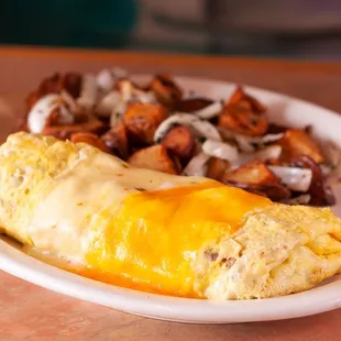 an omelet, potatoes, and a glass of orange juice