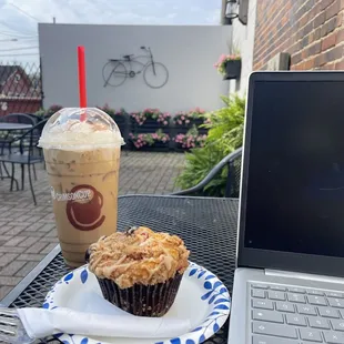 a cupcake on a plate next to a laptop