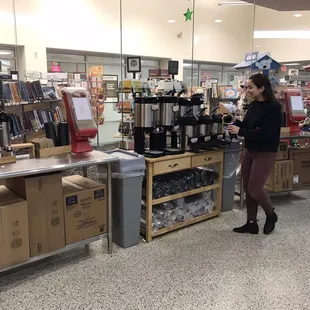 a woman standing in front of a coffee machine