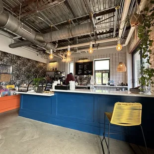  a blue counter with yellow chairs