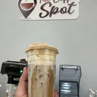 a hand holding a cup of iced coffee