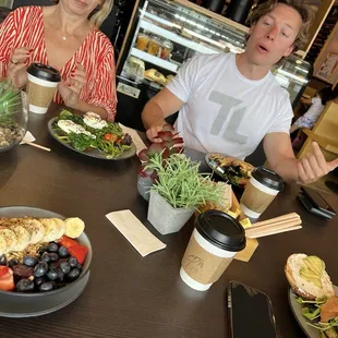 two people sitting at a table with food