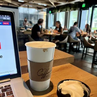 a cup of coffee next to a laptop