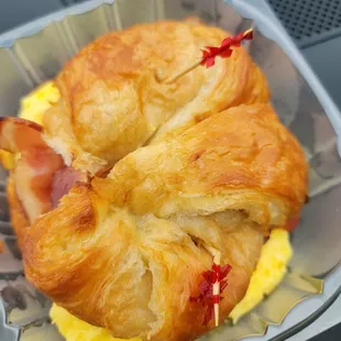 a croissant sandwich in a plastic container