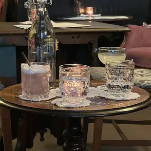 a table with two glasses and a bottle on it