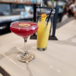 two cocktails on a bar