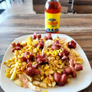a plate of food with a bottle of sauce in the background