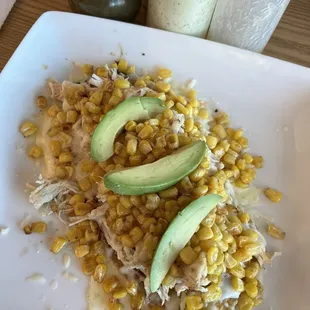Chicken, cheese, corn, and avocado over a warm sweet plantain