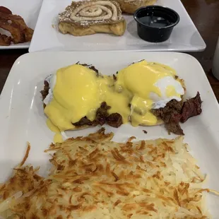 Brisket eggs benedict with a side of Hash Browns, cinnamon roll french toast, Bacon
