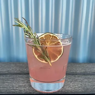 a drink with a sprig of rosemary
