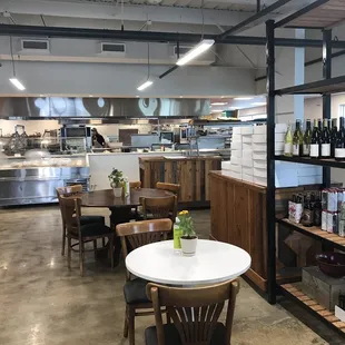 Tables for eating among the store. Cases with to go soups or salads. Also wines and sauces available for purchase.