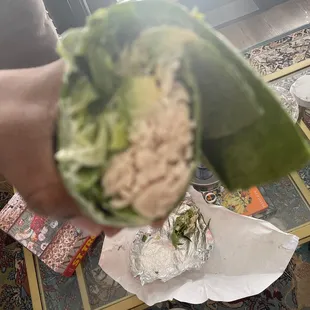 a person holding a lettuce leaf