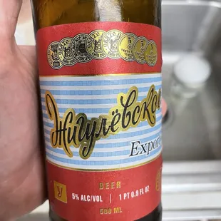 a hand holding a bottle of beer