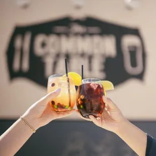 two people toasting with drinks