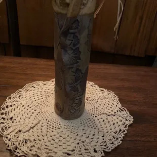 A clay vase with impressed leaves that firms a beautiful pattern.