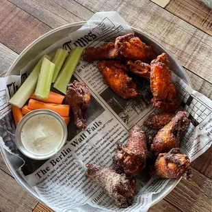 a plate of wings, carrots, celery, and celery sticks