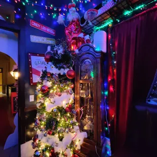a decorated christmas tree and a grandfather clock