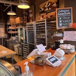 a woman standing at a counter in a bakery