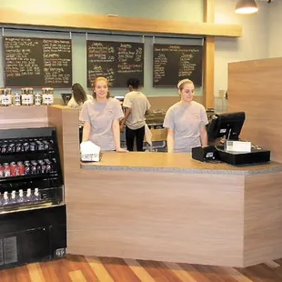 two women behind a counter in a coffee shop