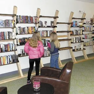 two children in a library with bookshelves