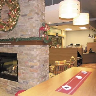 a living room with a fireplace and christmas decorations