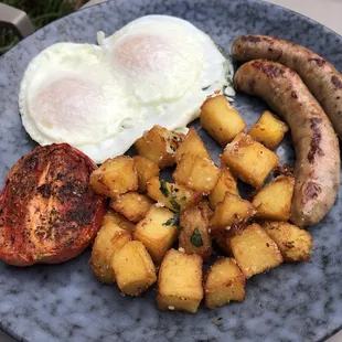 Eggs, home potatoes, tomato grilled, sausage.