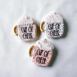 three decorated cup of cheer cookies