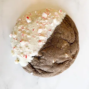 a chocolate cookie with white frosting and peppermink
