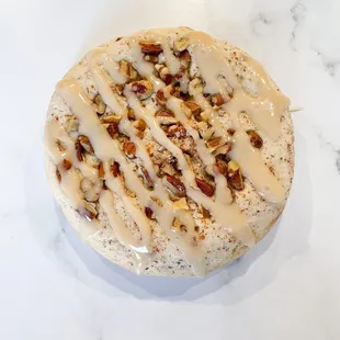 a frosted cake with nuts on top