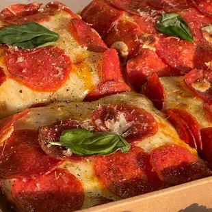 Pepperoni pizza by the slice with fresh mozzarella and basil