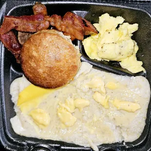 Big Back Plate with grits added cheese (cheese got stuck on the paper), eggs, biscuit, bacon, smoked sausage, pork link, and turkey pattie