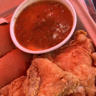 a tray of food including a hot dog and a bowl of sauce