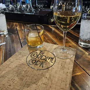 a glass of wine and a corked board