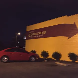 a red car parked in front of a yellow building
