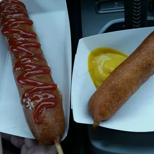 Footlong with ketchup and honey and a regular corn dog with mustard.