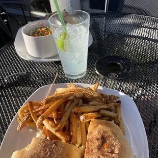 Fish sandwich with substituted shrimp and a margarita with fries.