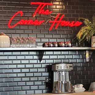 a brick wall with a neon sign above it