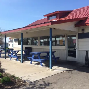 the outside of a restaurant with picnic tables