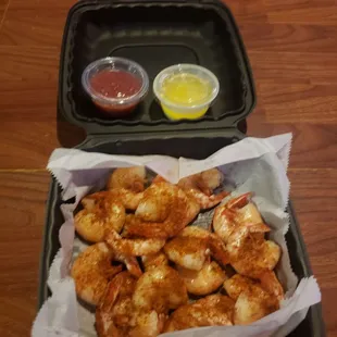 a tray of shrimp and dipping sauce