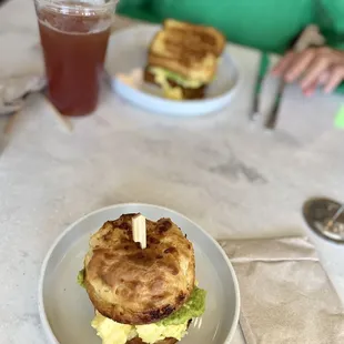 Scrambled egg, cheese &amp; avocado on warmed cheddar bisc. (front) &amp; brioche toast w/Arnold Palmer--same sandwich, different bread!