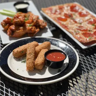 a plate of chicken nuggies and a plate of pizza