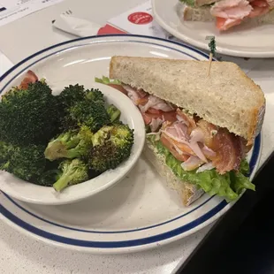 Half a turkey BLT sandwich with a side of roasted broccoli