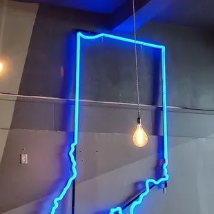 a man sitting in front of a neon sign